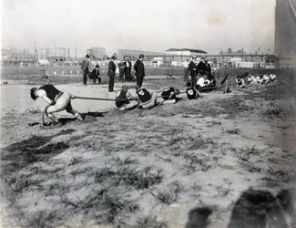 Horizontal Photograph of Two Teams Competing in Tug of War with Judges Standing Behind the Rope
